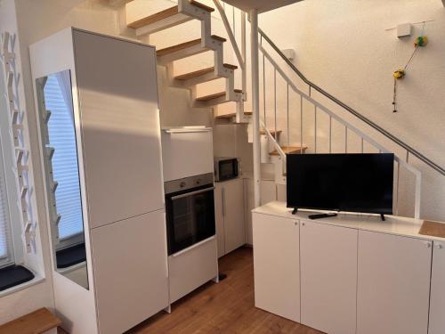 a living room with white cabinets and a staircase at Traumhaft moderne Ferienhaus-Tiny House in 78554 Aldingen in Aldingen