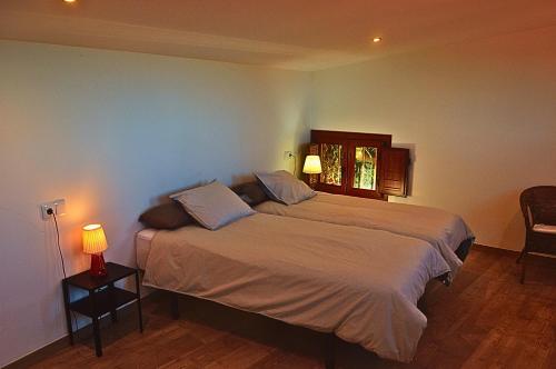 a bedroom with a bed and a mirror and a lamp at Cabaña con Piscina en Doniños in Doniños