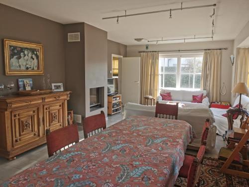 a bedroom with a table and a bed and a room at Vlierhof in Sint-Idesbald