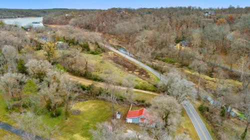 an aerial view of a house and a road next to a river at Creekside Cabin - Beaver Lake Creek Access in Rogers