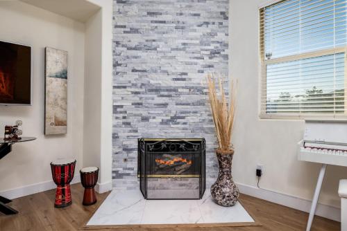 a fireplace in a living room with a brick wall at Music Lovers Paradise 7 Bed Pool Home and Game Room in Indio
