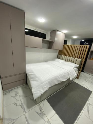 Cette petite chambre comprend un lit avec des draps blancs. dans l'établissement Studio Dijon, à Dijon