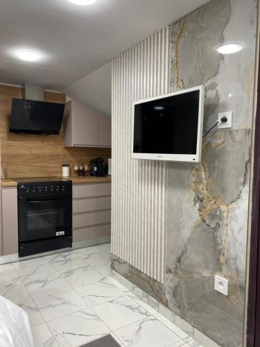 une cuisine avec une télévision suspendue au mur dans l'établissement Studio Dijon, à Dijon