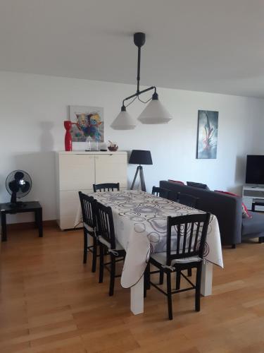 a living room with a table with chairs and a couch at Gîte les Griffons in Clairvaux-les-Lacs