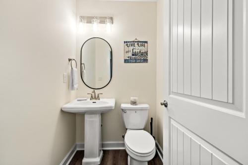 a bathroom with a toilet and a sink and a mirror at Heated Pool & Pet Friendly - Minutes To Beach - Spacious Backyard - FLPCB38 in Panama City Beach
