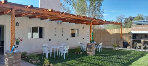 patio con tavolo e sedie sotto un pergolato in legno di Un Rincón De Lourdes a San Rafael