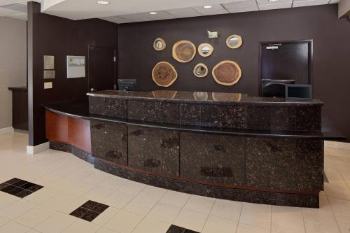 a lobby with a counter with plates on the wall at Courtyard Fort Worth I-30 West Near NAS JRB in Fort Worth