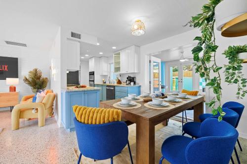 a kitchen and dining room with a wooden table and blue chairs at Private Pool 6 MI to Clearwater Beach Fire Pit Game Room in Clearwater