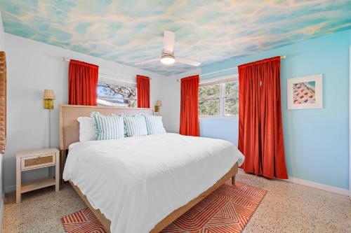 a bedroom with a bed and red curtains at Villa w pool game room & putting green in Clearwater