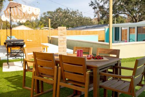 a wooden table and chairs in a backyard with a grill at Villa w pool game room & putting green in Clearwater