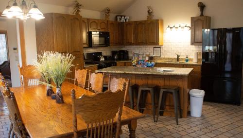 a kitchen with a wooden table and a black refrigerator at The Oakwood house in Rising Fawn