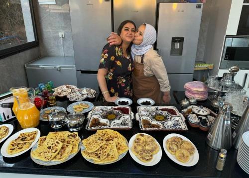 two women standing in front of a table of food at RIAD REDWAN in Marrakech