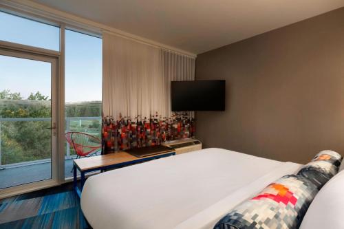 a hotel room with a bed and a window at Aloft Hillsboro-Beaverton in Hillsboro