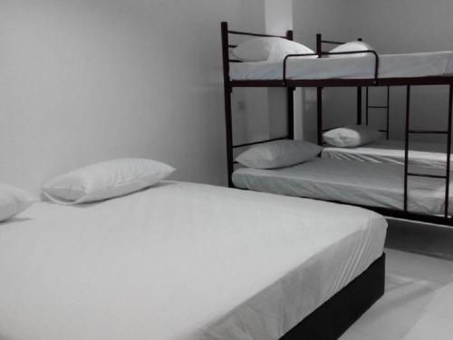 a bedroom with two bunk beds with white sheets at Pangkor Home Sea Village in Pangkor