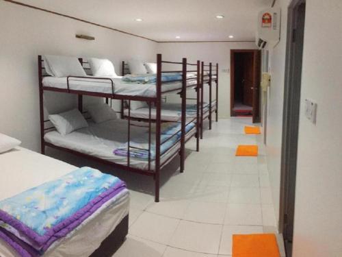 a room with four bunk beds and a hallway at Pangkor Home Sea Village in Pangkor