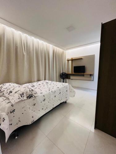 una camera da letto con un letto con copriletto a fiori di Sunset House - Casa de praia ad Aracaju
