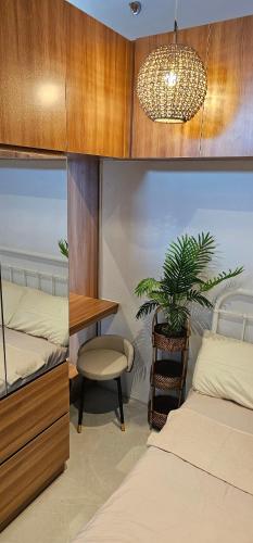 a bedroom with two beds and a desk and a potted plant at Cozy Flat in City Center in Cebu City