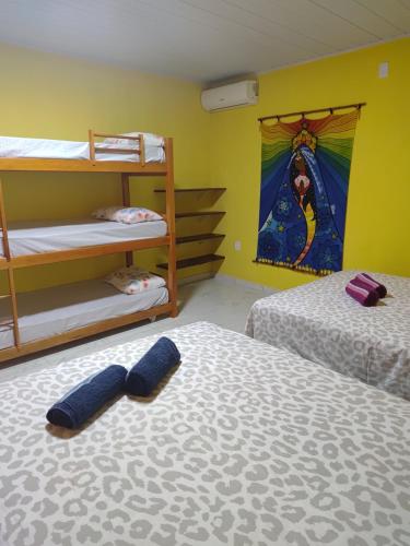 two beds in a room with two bunk beds at Pousada Paraíso Beach in Santa Cruz Cabrália