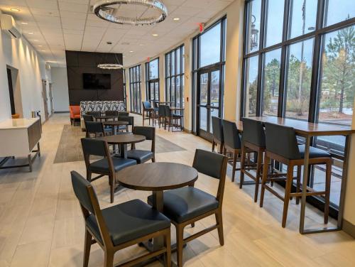 a dining room with tables and chairs and windows at Holiday Inn Carbondale - Conference Center by IHG in Carbondale