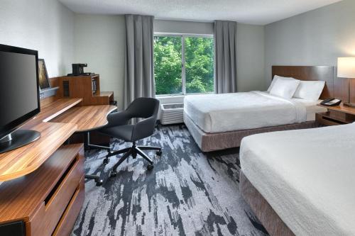 a hotel room with two beds and a desk with a computer at Fairfield Inn & Suites by Marriott Frankenmuth in Frankenmuth