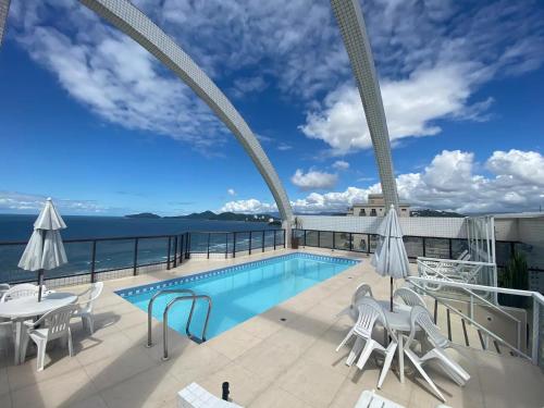 a swimming pool on the roof of a building at Flat em frente ao mar com piscina varanda e AC in Santos