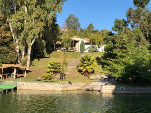 a house on the shore of a body of water at CASA COSTA DEL SOL 2 Lago Rapel in Melipilla
