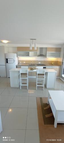 a white kitchen with white tables and white appliances at Apartamento Acapulco in Punta del Este