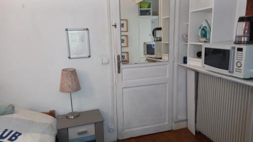 - une chambre avec une porte, un four micro-ondes et un lit dans l'établissement REF 11 studio BAGNEUX 5 minutes à pied métro ligne 4, à Bagneux