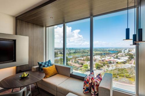 a living room with a couch and a large window at Aloft Perth in Perth