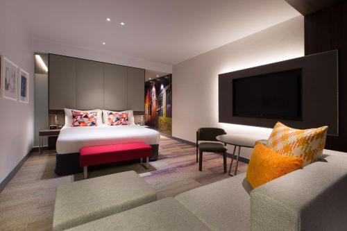 a hotel room with a bed and a flat screen tv at Aloft Perth in Perth