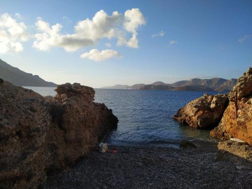 a group of rocks on a beach near the water at Armeos Blue in Myrties