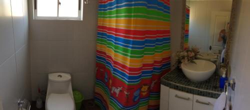 a bathroom with a colorful shower curtain next to a sink at CASA COSTA DEL SOL 2 Lago Rapel in Melipilla