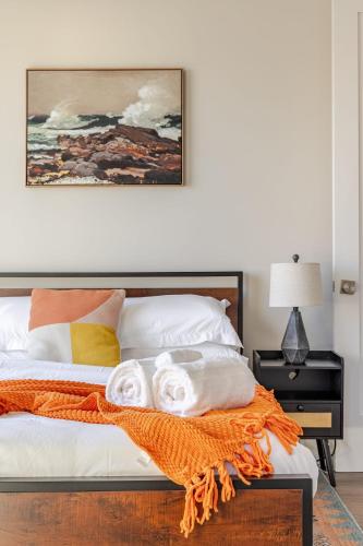 a bedroom with a bed with an orange blanket at NYC Gateway, 30minutes from Manhattan in Jersey City