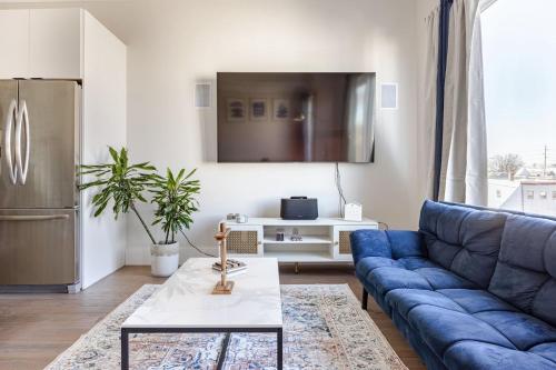 a living room with a blue couch and a table at NYC Gateway, 30minutes from Manhattan in Jersey City