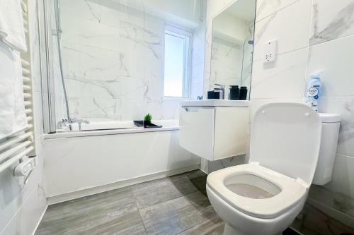 a white bathroom with a toilet and a shower at Modern 2 Bed Flat by Heathrow Airport, Free Parking in Harmondsworth