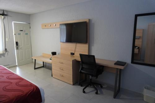 a bedroom with a desk with a television and a bed at Quality Inn Piedras Negras in Piedras Negras