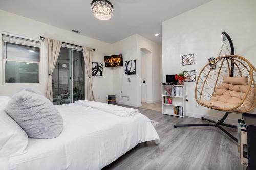 a bedroom with a white bed and a chair at Music Lovers Paradise 7 Bed Pool Home and Game Room in Indio