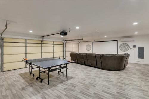 a room with a ping pong table and a screen at Impressive 5BR 3,5BA Holiday Home with Pool, Game Room & Cinema Room in Irving