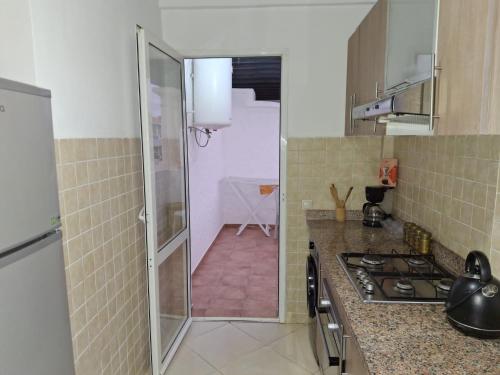 a small kitchen with a stove and a sink at Garden Beach 2 sidi rahal in Sidi Rahal