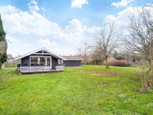 a small house in a field with a grass yard at 6 person holiday home in Skibby-By Traum in Skibby