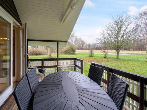 a table on a porch with an umbrella at 6 person holiday home in Skibby-By Traum in Skibby