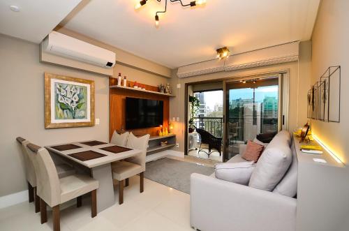 a living room with a white couch and a table at Home Batel in Curitiba