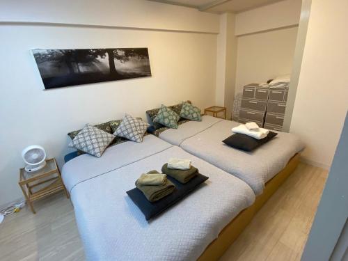 a bedroom with two beds with towels on them at 新大阪徒步30秒 Shinosaka Station 30s, Direct to Kansai Airport 關西空港直達, Universal Studio 16 mins, Umeda 6 mins, Kyoto 25 mins, Early Check in in Osaka