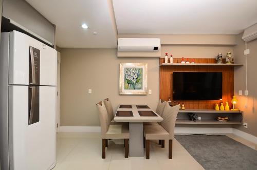 a kitchen with a table with chairs and a refrigerator at Home Batel in Curitiba
