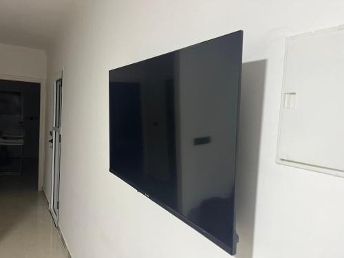 a flat screen tv hanging on a wall at Al hanaa in Monte ʼArrouit