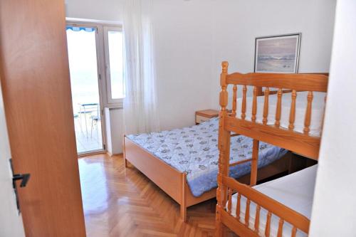 a small bedroom with a bunk bed and a window at Apartments Draga in Metajna