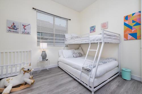 a bedroom with a bunk bed and a white bed at Music Lovers Paradise 7 Bed Pool Home and Game Room in Indio
