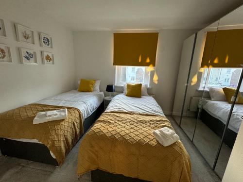 a small room with two beds and a mirror at 2 Bed House near Canary Wharf in London