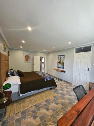 a bedroom with a bed and a table in a room at StoneWoodGrey in Harare