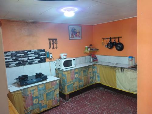 una cucina con fornelli e microonde di Cabinas Rhode island a Cahuita